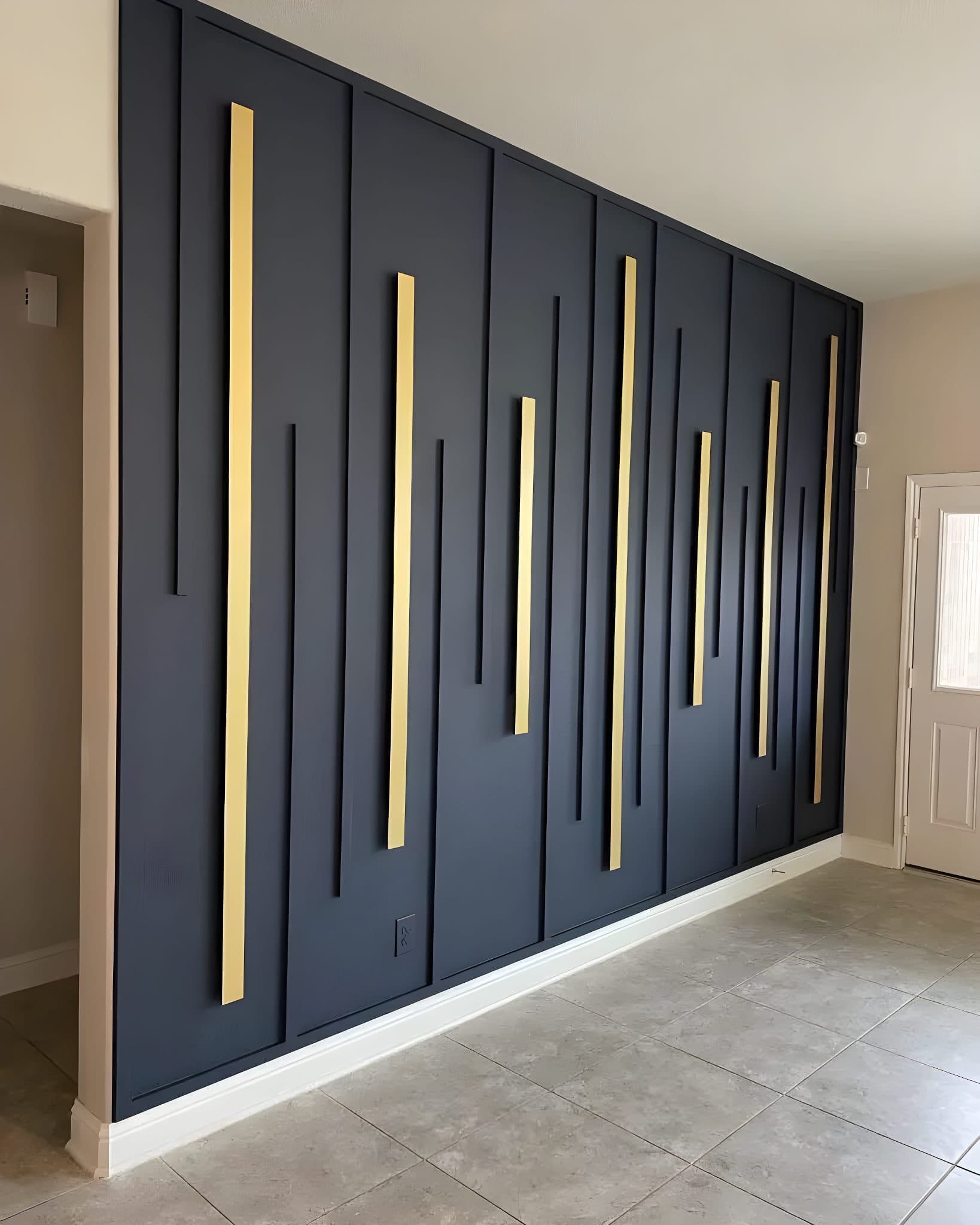 Modern black accent wall with gold vertical panels, a unique custom wallpaper installation.