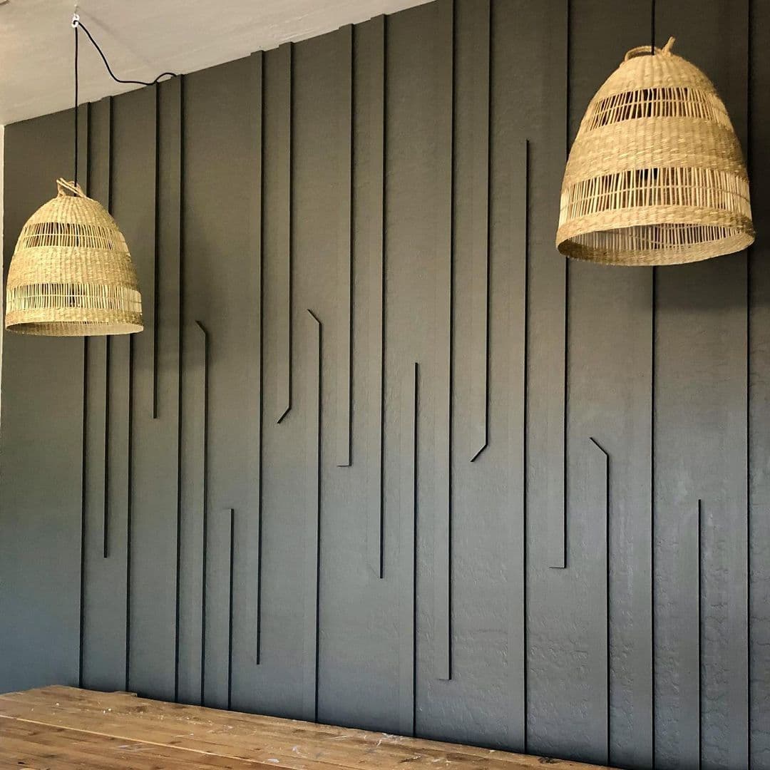 A modern accent wall with vertical wooden slats and two wicker pendant lights, suitable for custom wallpaper.