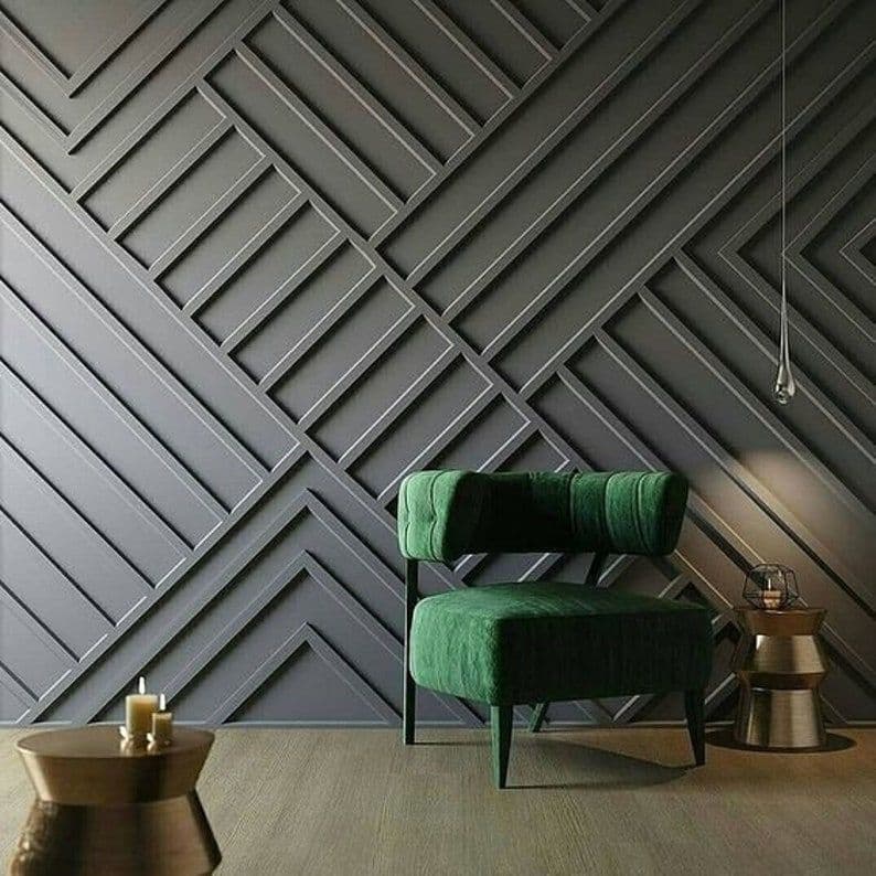 Dramatic grey geometric wall paneling with a green velvet chair, perfect for bespoke wallpaper installations.